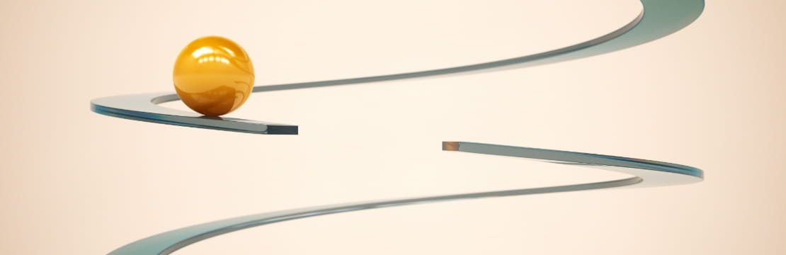 Golden sphere resting on a winding, metallic spiral track against a light background.